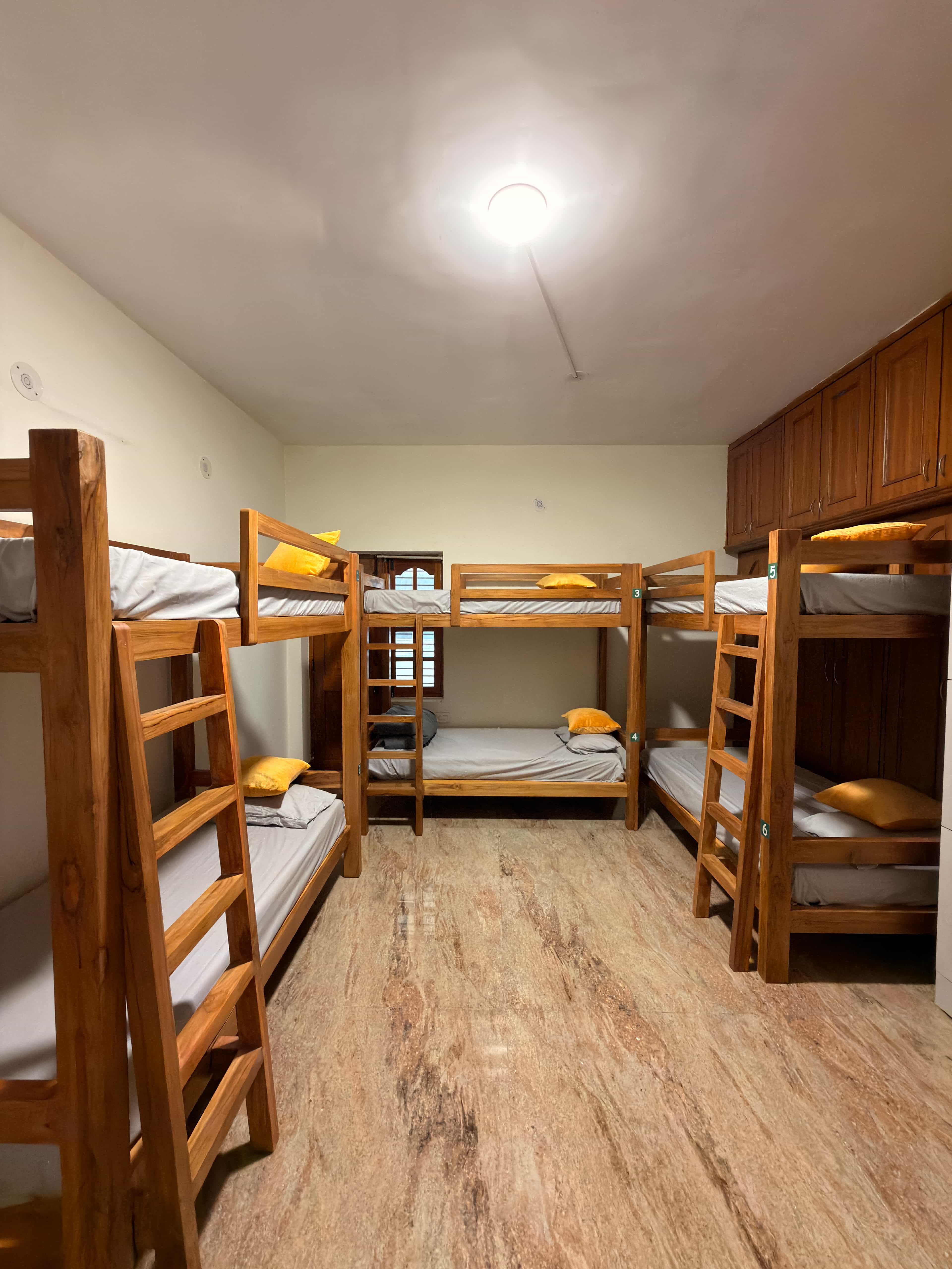 AC dorm room with wooden bunk beds at Nirvana Backpackers, Tirupati