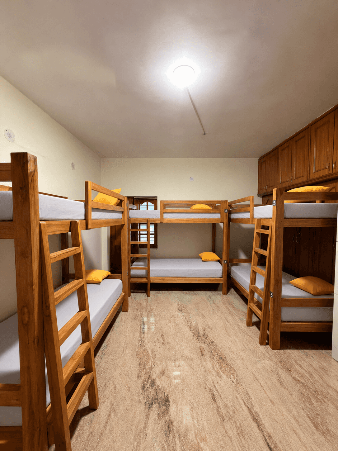 6-bed mixed AC dorm with wooden bunk beds at Nirvana Backpackers, Tirupati