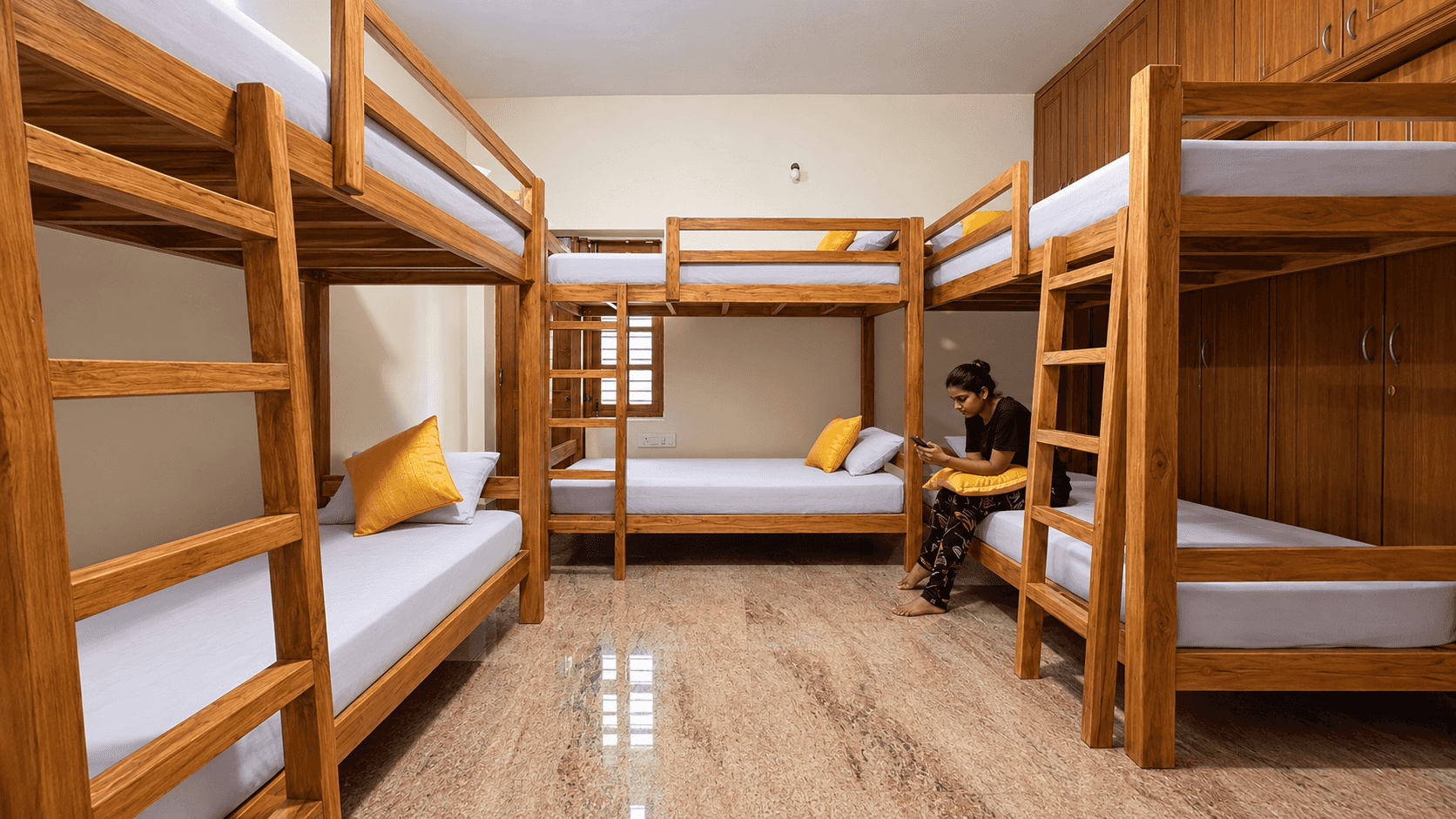 6-bed female-only AC dorm with wooden bunk beds at Nirvana Backpackers, Tirupati