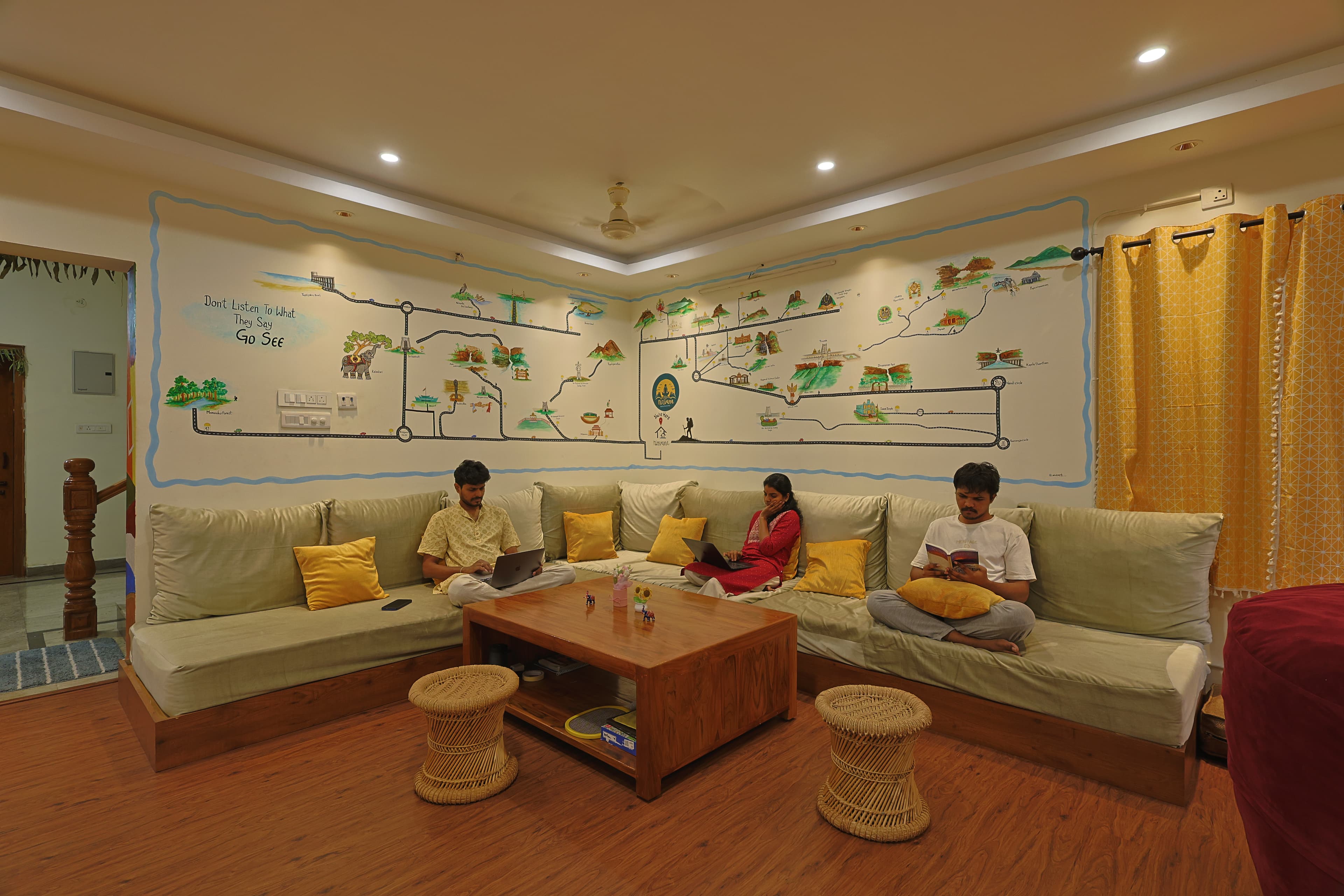 Guests relaxing in the lounge under the hand-painted travel map