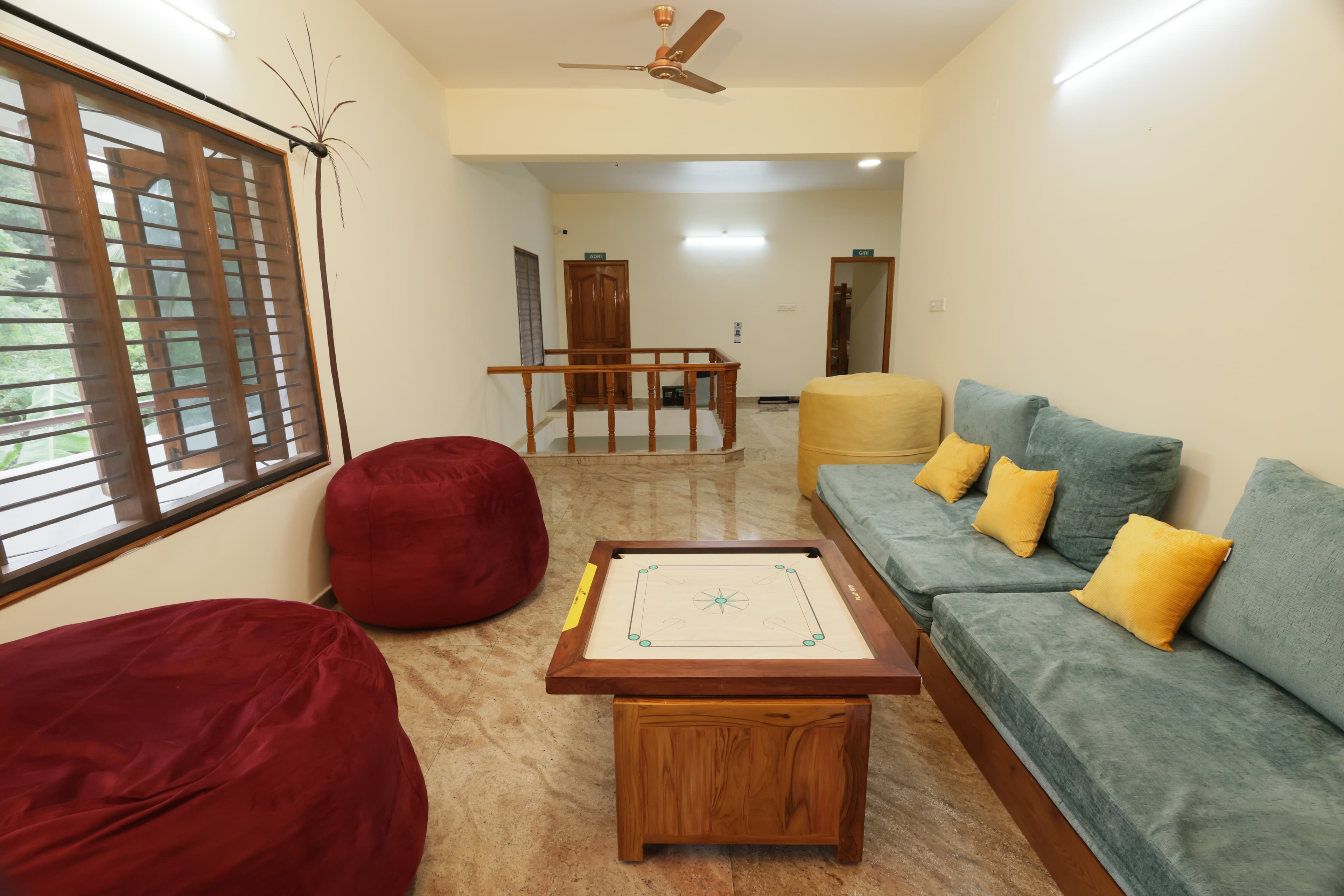 Living room with sofas, bean bags and a carrom board