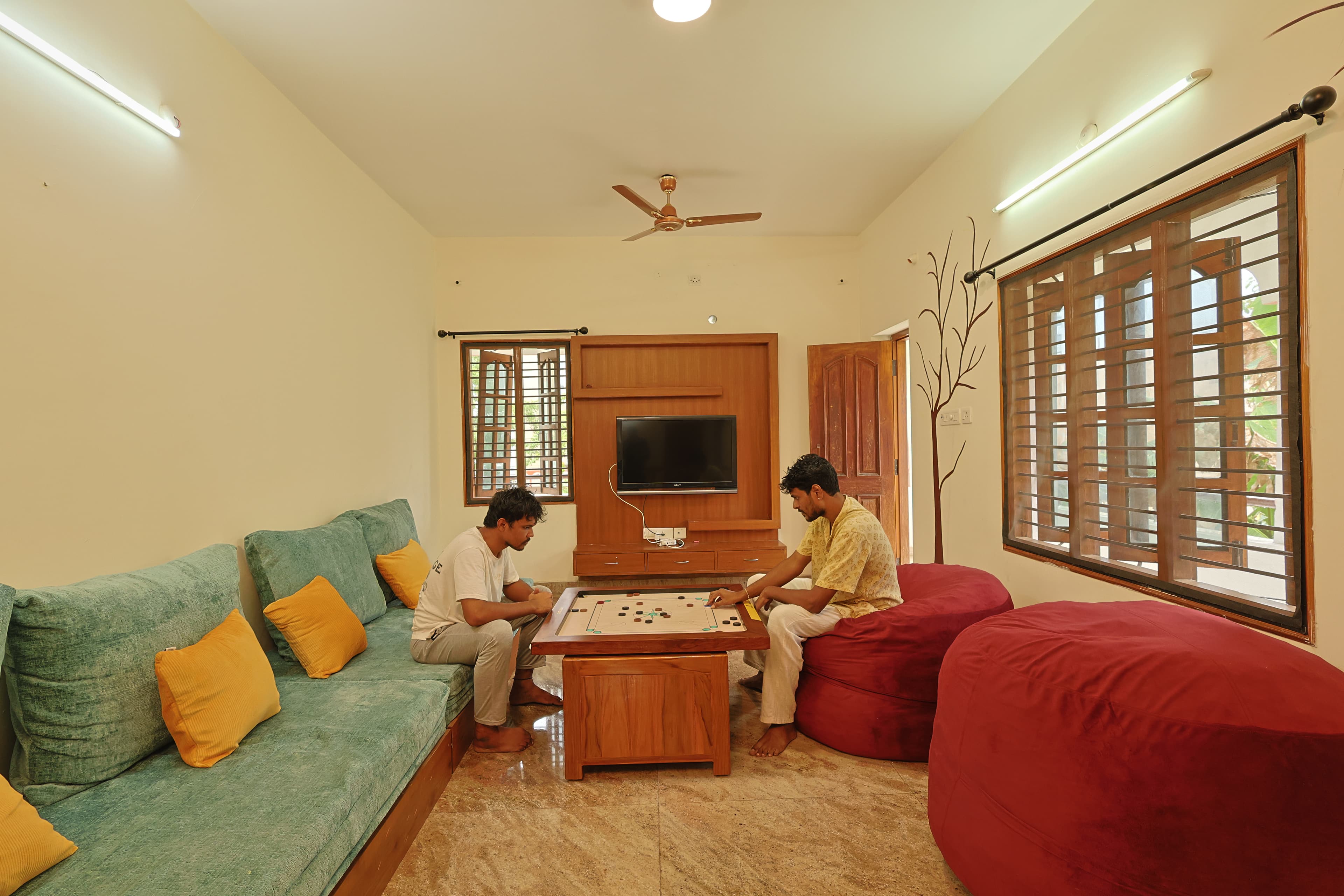 Guests playing carrom in the living room
