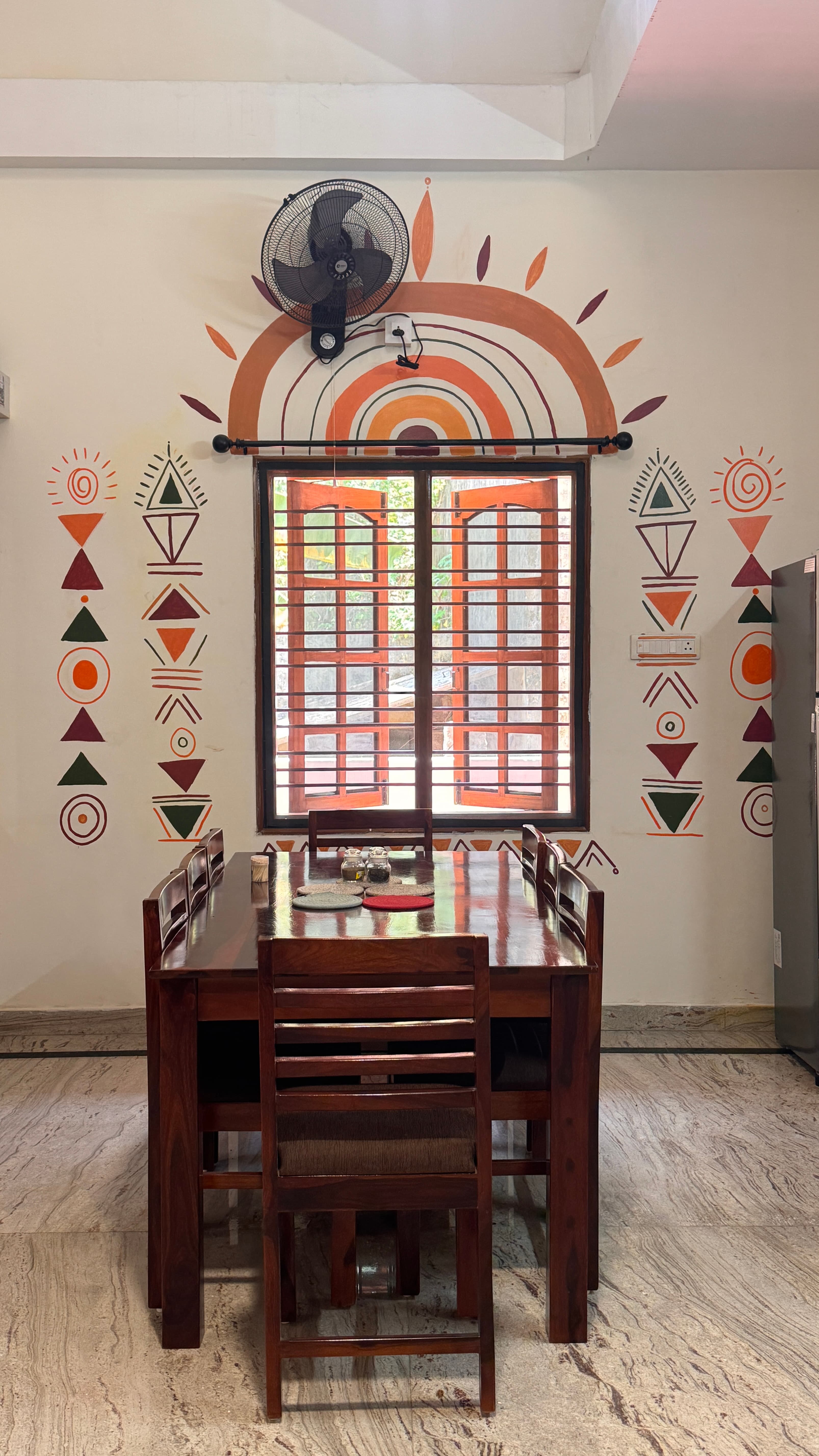 Dining table under a painted sun mural